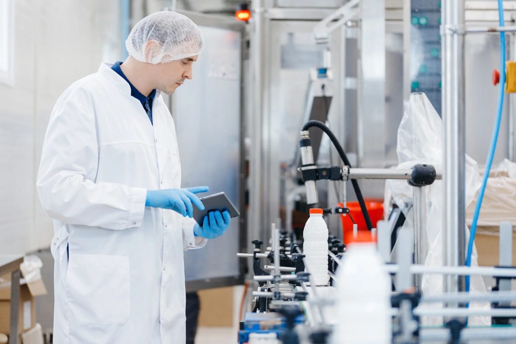 Technician operating an automated inkjet marking system on a production floor