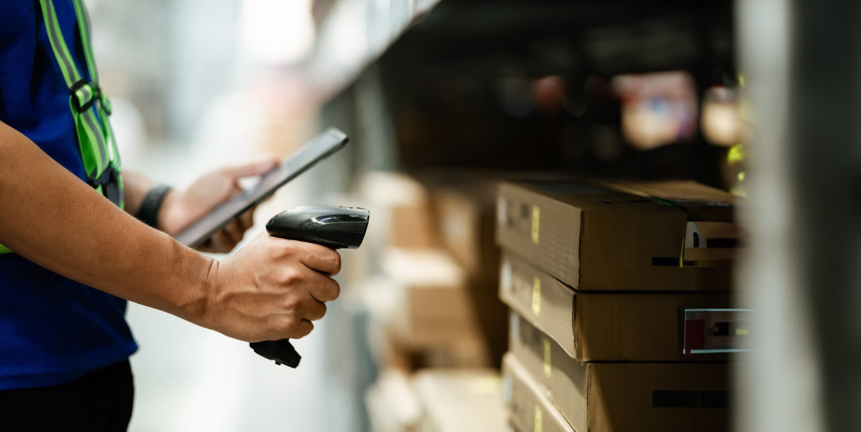 Warehouse worker scanning 2D barcode label on packaged product for tracking and inventory management.