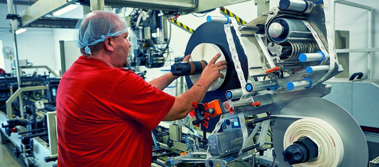 Factory operator overseeing connected system as part of modern Industry 4.0 manufacturing process.