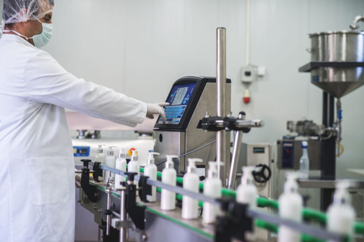 Automated packaging line with CPG services equipment applying product coding and labeling in a manufacturing facility.